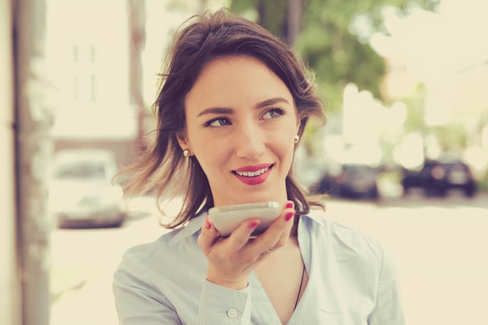 A person uses a voice assistant on a smartphone.